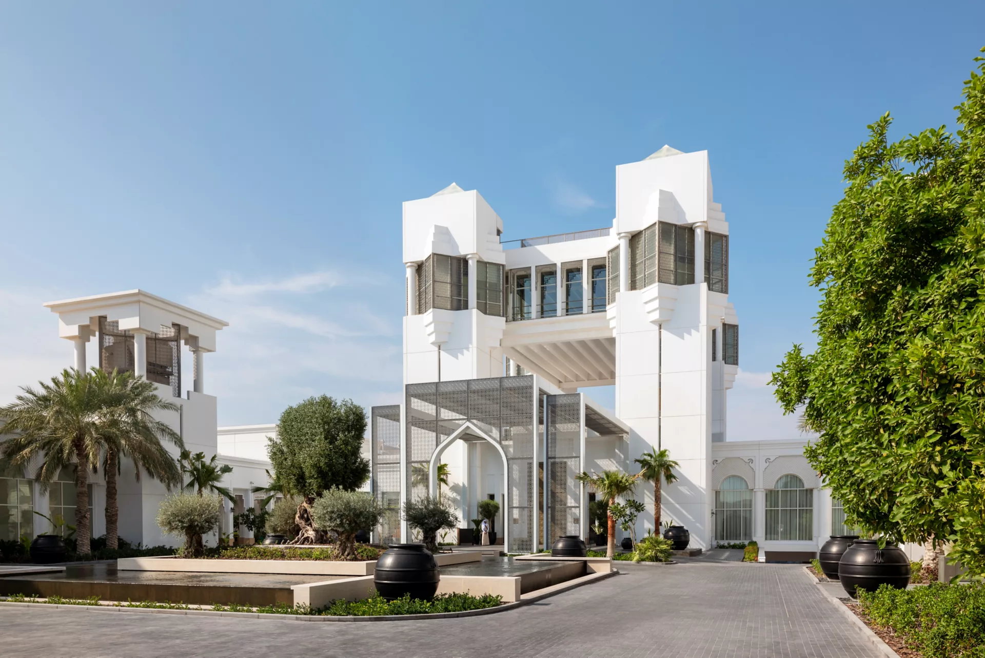 Grand entrance of Raffles Al Areen Palace with twin towers and landscaped gardens
