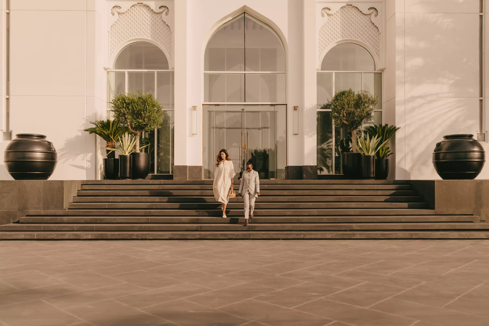 Elegantly dressed guests descending the grand palace entrance steps