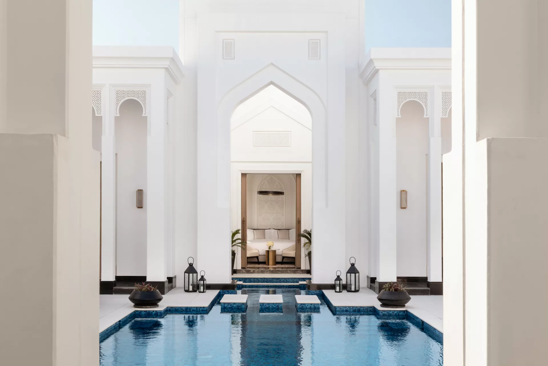 Private villa courtyard with turquoise reflecting pool and arched pavilion